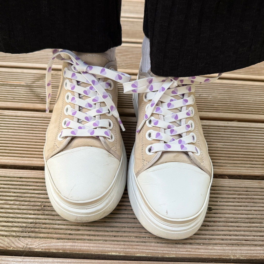 Lavender Heart balti batų raišteliai su violetinėmis širdelėmis ant smėlio spalvos sportbačio iš priekio