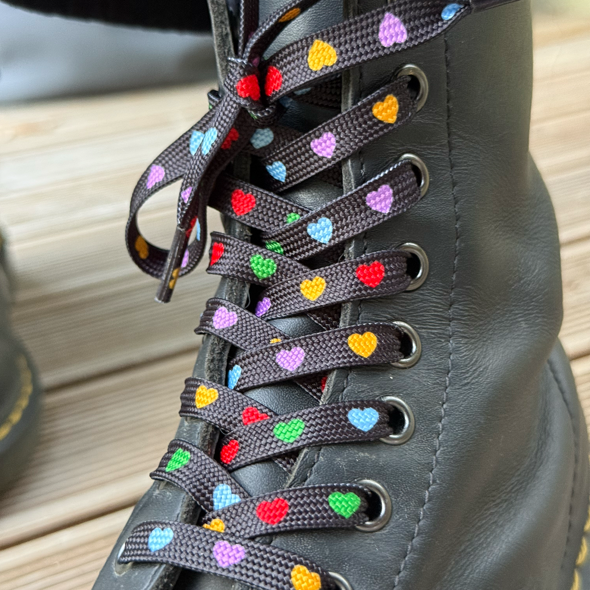 Rainbow Heart batų raištelių detalė su spalvotomis širdelėmis ant juodo bato